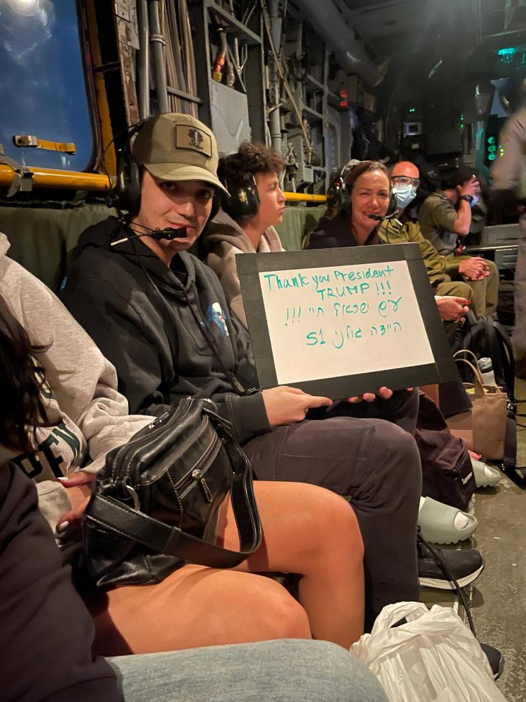 Edan Alexander holds up a sign thanking President Donald Trump.