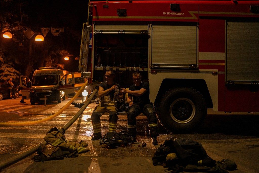 Firefighters pass water to each other after a Russian attack in Kyiv, Ukraine, Saturday, May 24, 2025