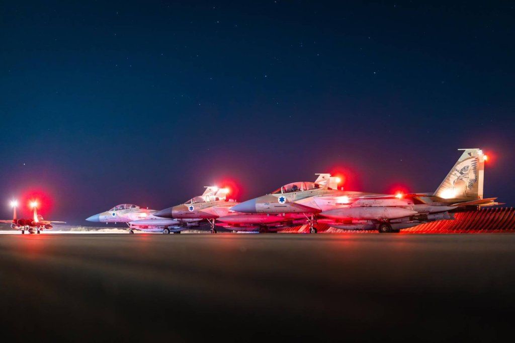 Israeli Air Force fighter jets on a runway at night.
