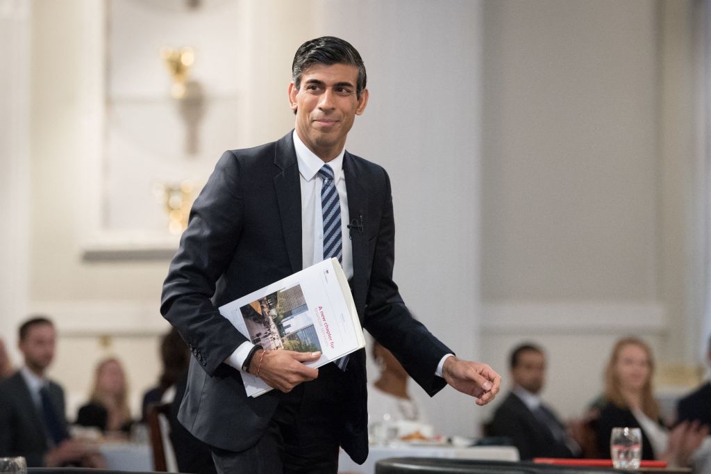 Rishi Sunak holding a document titled 