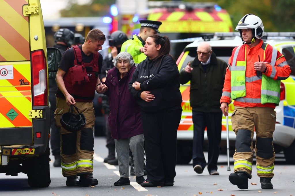 Emergency services personnel assisting community members after a major incident at a synagogue.