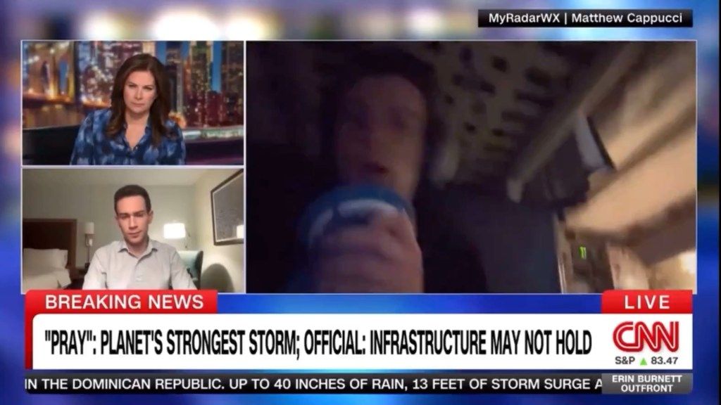 Screenshot of a CNN broadcast with a female anchor, a male reporter, and a man sheltering during a storm, with a news ticker about the planet's strongest storm.
