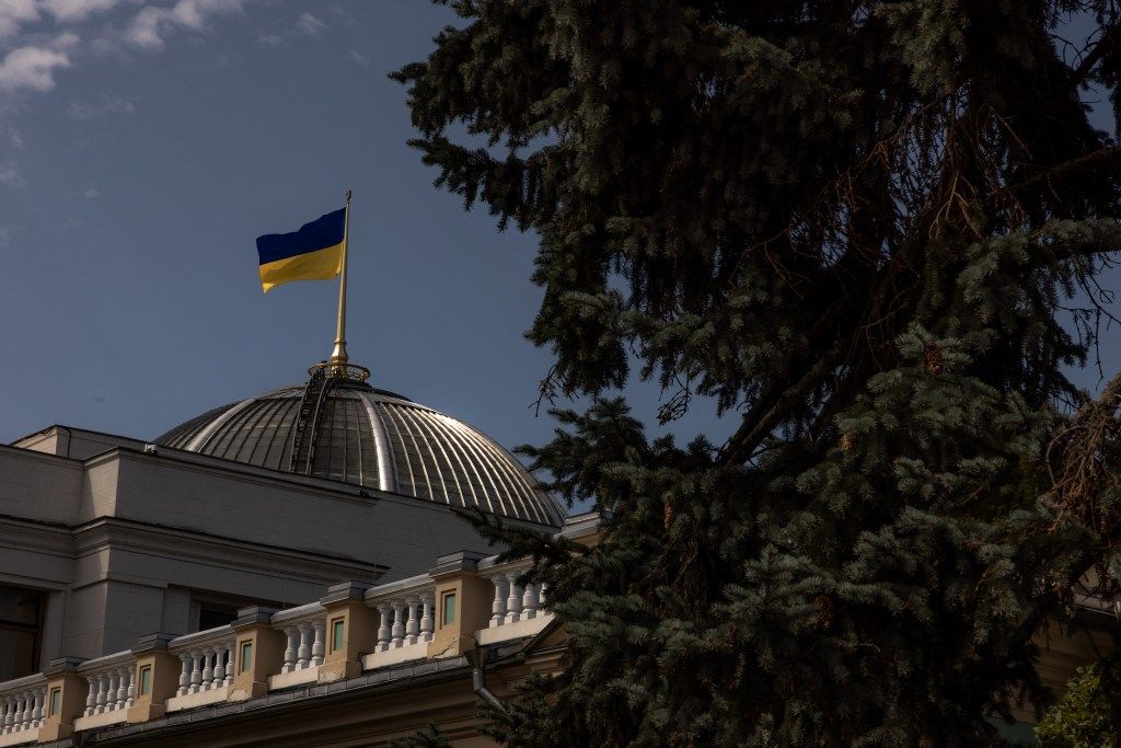 Ukrainian flag fluttering over the Verkhovna Rada building in Kyiv.