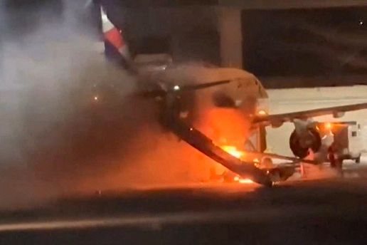 A Latam Airlines plane engulfed in fire and smoke on the tarmac at Guarulhos International Airport in Sao Paulo, Brazil.