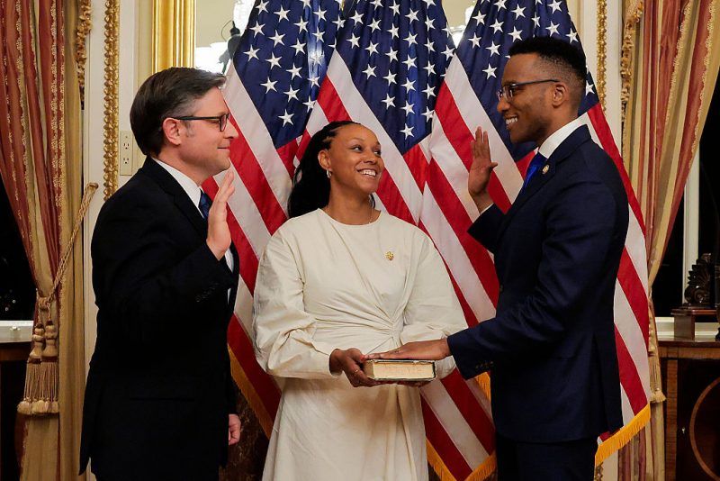 WASHINGTON, DC - FEBRUARY 02: (EDITORS NOTE: Retransmission with alternate crop.) U.S. Speaker of the House Mike Johnson (R-LA) (L) swears in Rep. Christian Menefee (D-TX) (R) while his wife Kaitlyn Menefee holds the bible at the U.S. Capitol on February 02, 2026 in Washington, DC. Menefee's election victory puts House Democrats at 214 seats to Republicans' 218, narrowing the margin of the Republicans' majority. (Photo by Heather Diehl/Getty Images)