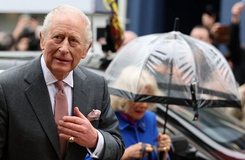 ST AUSTELL, ENGLAND - MARCH 24: Britain's Queen Camilla shelters from the rain beneath an umbrella as she and Britain's King Charles III arrive to visit Holy Trinity Church on March 24, 2026 in St Austell, England. (Photo by Adrian Dennis - WPA Pool/Getty Images)