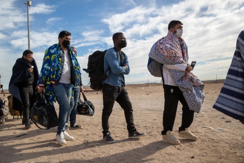 YUMA, ARIZONA - DECEMBER 07: Immigrant men are taken into custody by U.S. Border Patrol agents at the U.S.-Mexico border on December 07, 2021 in Yuma, Arizona. Most had come with their families through a nearby gap in the border wall in previous days to seek political asylum in the United States. Women and children were transported to processing facilities first. Border Patrol detention facilities in Yuma were overwhelmed with thousands of new arrivals, with many families trying to reach U.S. soil before the court-ordered re-implementation of the Trump-era Remain in Mexico policy. The policy requires asylum seekers to stay in Mexico for the duration of their U.S. immigration court process. (Photo by John Moore/Getty Images)