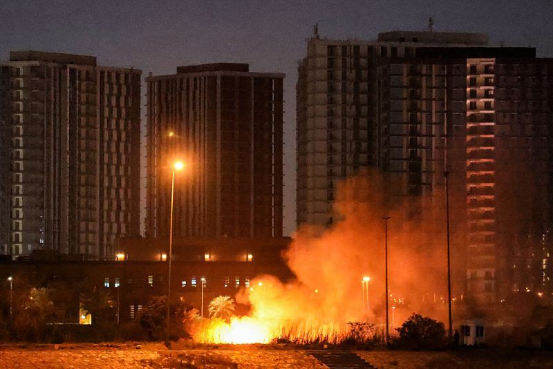 CORRECTION / A fire burns outside the grounds of the US Embassy headquarters in Baghdad's fortified "Green Zone" on March 17, 2026 following a drone and rocket attack according to security officials. The strikes came hours after air defences thwarted a rocket attack at the embassy and a drone sparked a fire at a luxury hotel frequented by foreign diplomats in the Green Zone. Iraq was drawn into the Middle East war after having long been a proxy battleground between the US and Iran, with strikes targeting Iran-backed groups that have claimed daily attacks on US interests in Iraq and across the region. (Photo by AHMAD AL-RUBAYE / AFP via Getty Images) / "The erroneous mention[s] appearing in the metadata of this photo by AHMAD AL-RUBAYE has been modified in AFP systems in the following manner: [outside the grounds] instead of [on the grounds]. Please immediately remove the erroneous mention[s] from all your online services and delete it (them) from your servers. If you have been authorized by AFP to distribute it (them) to third parties, please ensure that the same actions are carried out by them. Failure to promptly comply with these instructions will entail liability on your part for any continued or post notification usage. Therefore we thank you very much for all your attention and prompt action. We are sorry for the inconvenience this notification may cause and remain at your disposal for any further information you may require."