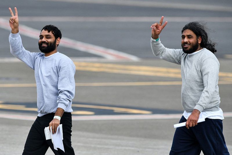 Migrants deported from the United States gesture as they walk on the runway upon arrival at Juan Santamaria International Airport in Alajuela, Costa Rica on April 11, 2026. US on April 11, 2026, deported 25 foreign migrants to Costa Ricathe first under an agreement that allows it to send that number of deportees from third countries to the Central American nation each week while their status is being resolved. (Photo by Ezequiel BECERRA / AFP via Getty Images)