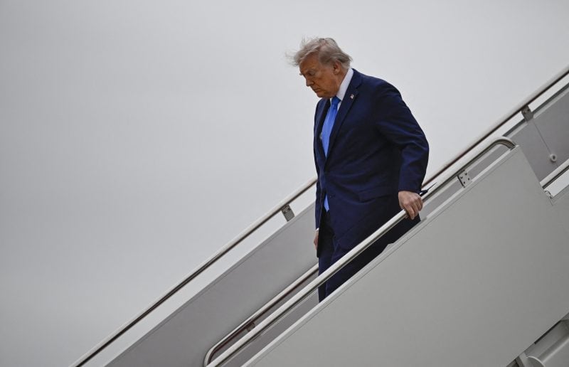 US President Donald Trump steps off Air Force One at Joint Base Andrews, Maryland, upon his return from Florida, on April 25, 2026. (Photo by Kent NISHIMURA / AFP via Getty Images)