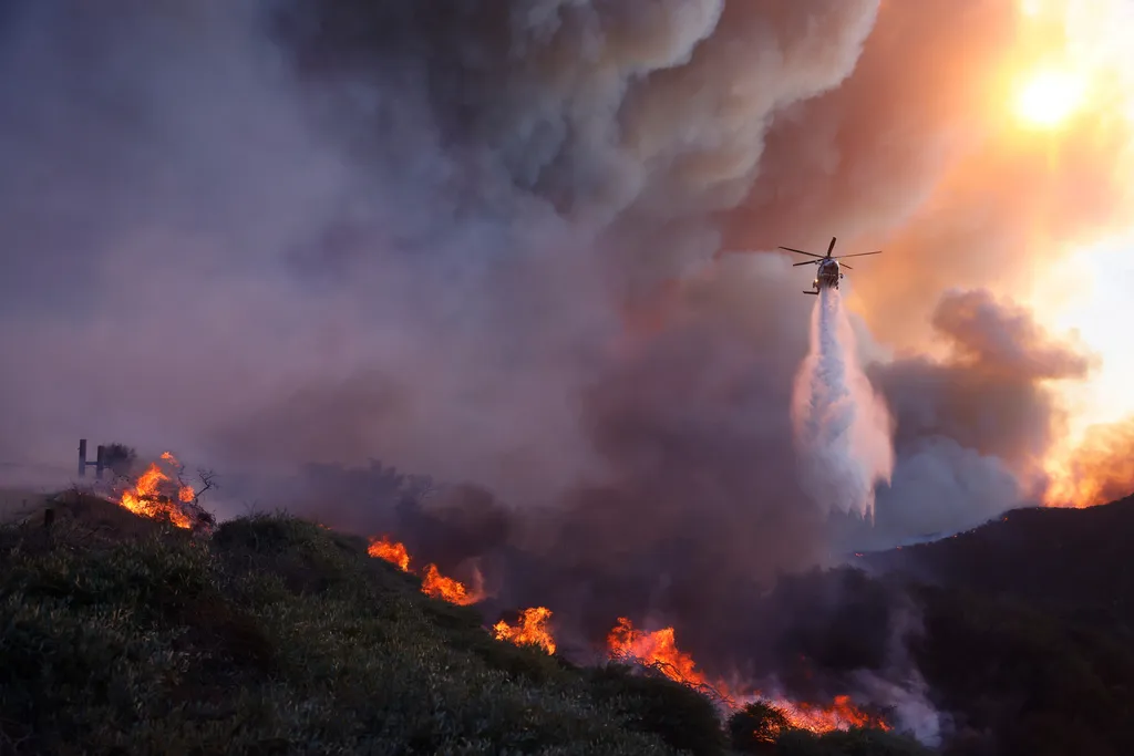Helicopter drops water onto a wildfire.