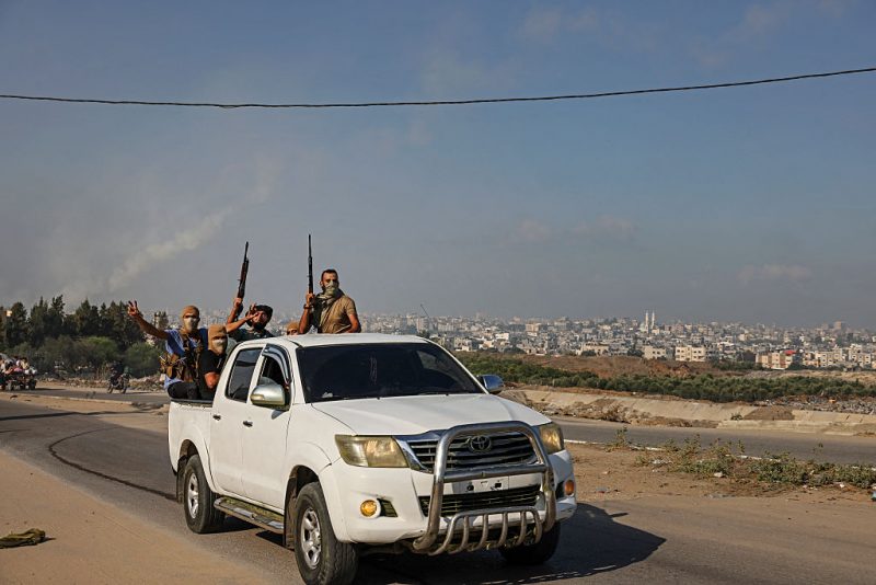 Palestinian militants of the Ezzedine al-Qassam Brigades move towards the Erez crossing between Israel and the northern Gaza Strip on October 7, 2023. Hundreds of residents in the Gaza Strip fled their homes to move away from the border with Israel after barrages of rockets were fired from the coastal enclave into Israel, an AFP correspondent reported. (Photo by Mohammed ABED / AFP) (Photo by MOHAMMED ABED/AFP via Getty Images)