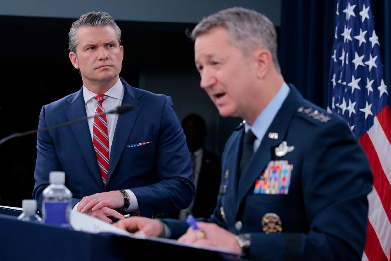 ARLINGTON, VIRGINIA - MAY 05: U.S. Secretary of War Pete Hegseth (L) looks on as Chairman of the Joint Chiefs of Staff Gen. Dan Caine speaks during a press briefing at the Pentagon on May 05, 2026 in Arlington, Virginia. Tensions remain high in the Strait of Hormuz as the U.S. and Iran traded shots on Monday after Trump said the U.S. military would open the strait for shipping. (Photo by Chip Somodevilla/Getty Images)