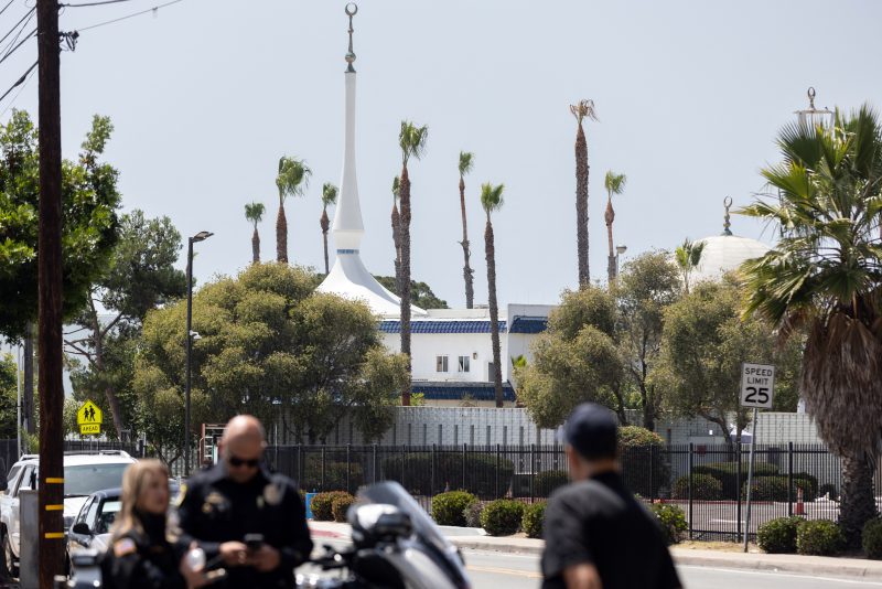San Diego Police officers stand blocking the road to the Islamic Center of San Diego following a shooting in southern California, on May 18, 2026. A shooting at the largest mosque complex in San Diego killed three people, with two suspected teenage gunmen later found dead in a car from self-inflicted gunshot wounds, police said. (Photo by Zoë Meyers / AFP via Getty Images)