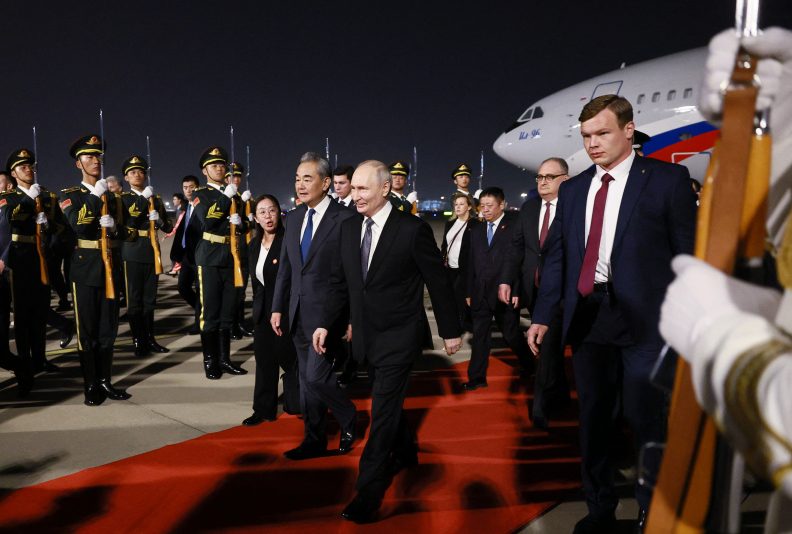 TOPSHOT - In this pool photograph distributed by the Russian state agency Sputnik, Russia's President Vladimir Putin is welcomed by Chinese Foreign Minister Wang Yi upon his arrival at Beijing Capital Airport in Beijing late on May 19, 2026. (Photo by Vladimir SMIRNOV / POOL / AFP via Getty Images)