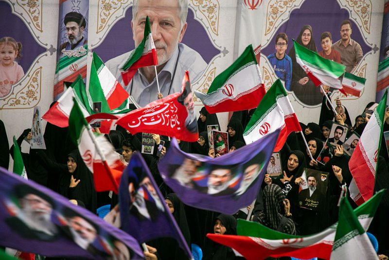 TEHRAN, IRAN - MAY 24: People hold portraits of the dead at the Imam Khomeini Mosalla Mosque to commemorate those killed in the current US-Israeli war as well as previous wars on May 24, 2026 in Tehran, Iran. President Donald Trump said a peace deal with Iran has been largely negotiated with details, including the reopening of the Strait of Hormuz, to be announced soon. (Photo by Majid Saeedi/Getty Images)