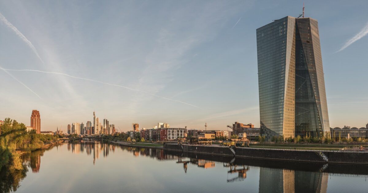 Real photo of the European Central Bank building and Frankfurt skyline at dawn for a euro stablecoin regulation story.