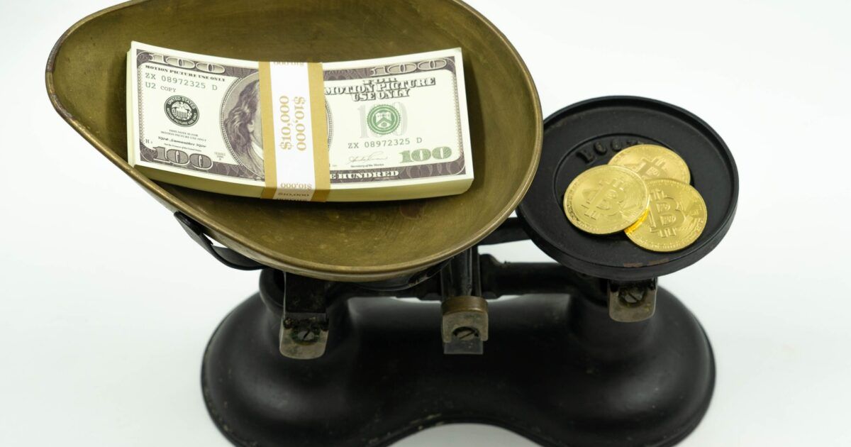 Real photo of physical Bitcoin medallions beside U.S. dollar bills, used for a Bitcoin-backed lending story.