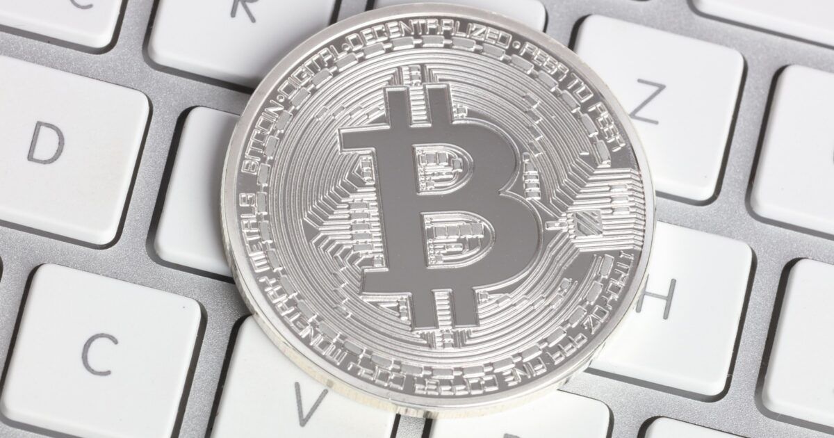 Physical Bitcoin coin photographed for a market rebound story after crypto liquidations.