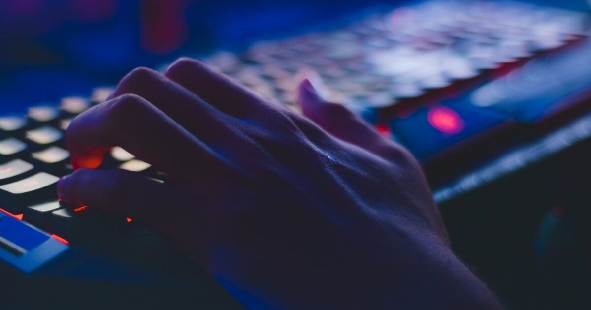 Hands typing on a computer keyboard for an AI-agent crypto wallet security story.