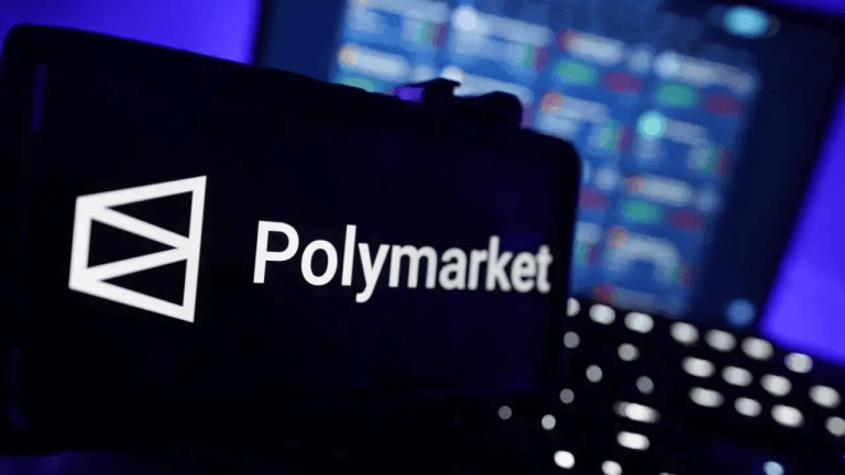 Polymarket on a smartphone with computer in background.
