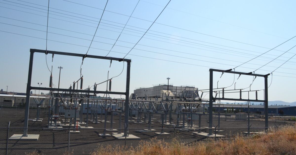 Data center buildings behind a high-voltage electrical substation
