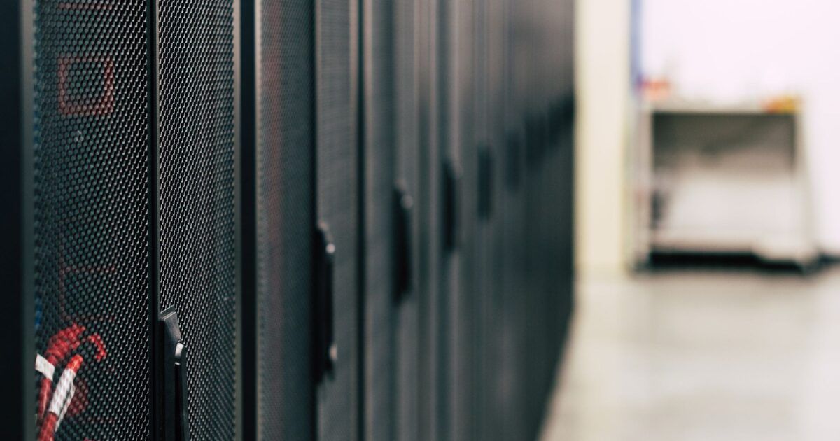 Server racks in a modern data center for an article about Empery Digital funding an AI infrastructure investment with Bitcoin sales.