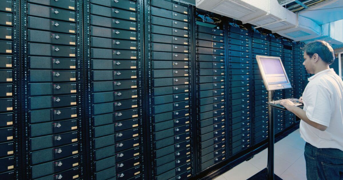 A technician working beside server racks in a data center for a ProCoinNews article about Ethereum node hosting.