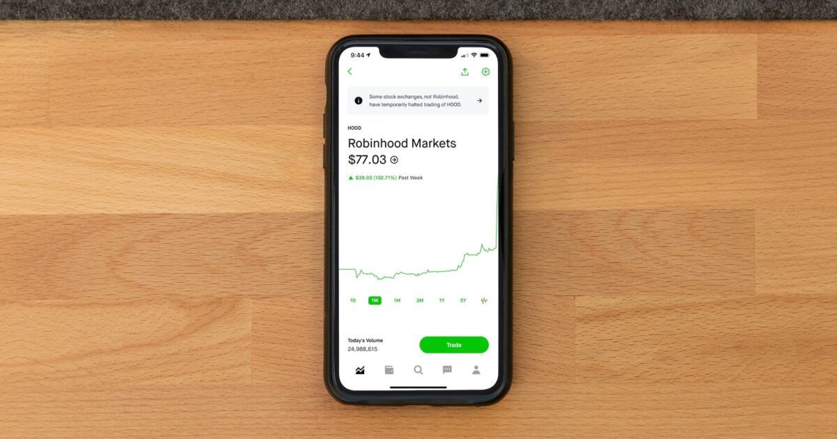 Person holding a phone with stock-market data for a ProCoinNews article about Robinhood Chain mainnet and tokenized stocks.