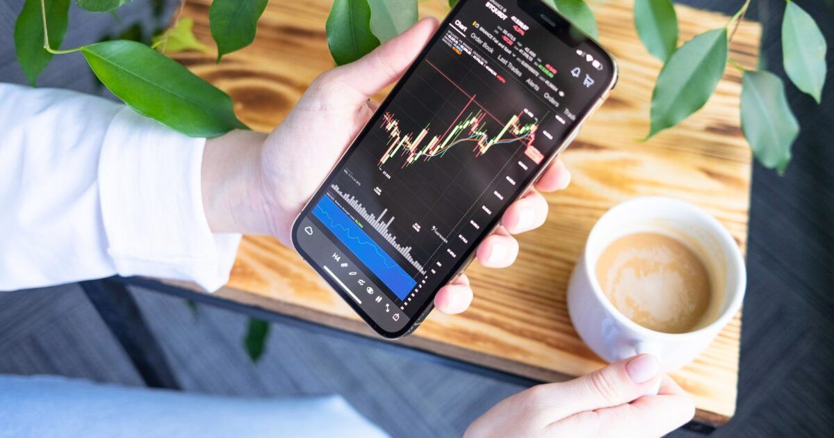 Person using a crypto trading app on a phone for a ProCoinNews article about World launching prediction markets inside Phantom.