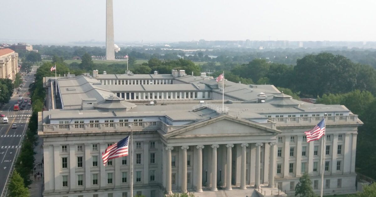 The U.S. Treasury building in Washington, D.C., with the Washington Monument in the background.