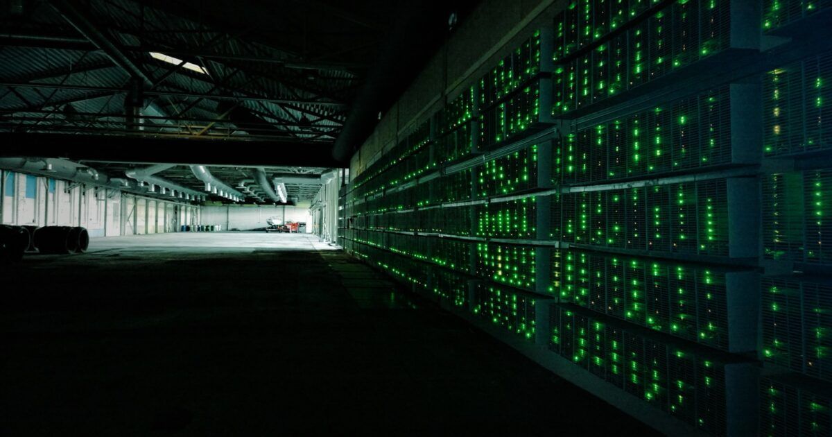 Rows of Bitcoin mining computers operating inside a mining facility