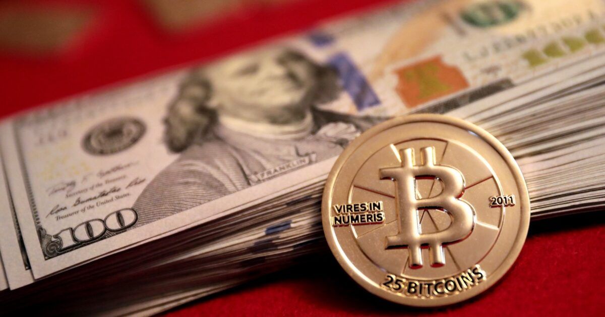 Physical Bitcoin coin beside U.S. dollar bills