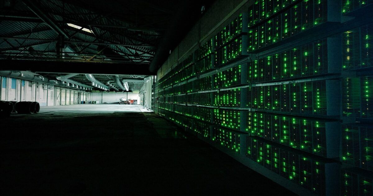 Rows of Bitcoin mining computers inside a working mining farm