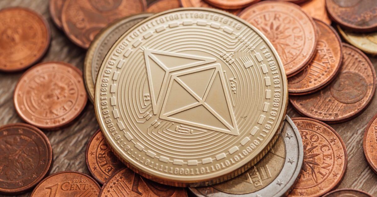 Physical Ethereum token resting on a field of fiat coins