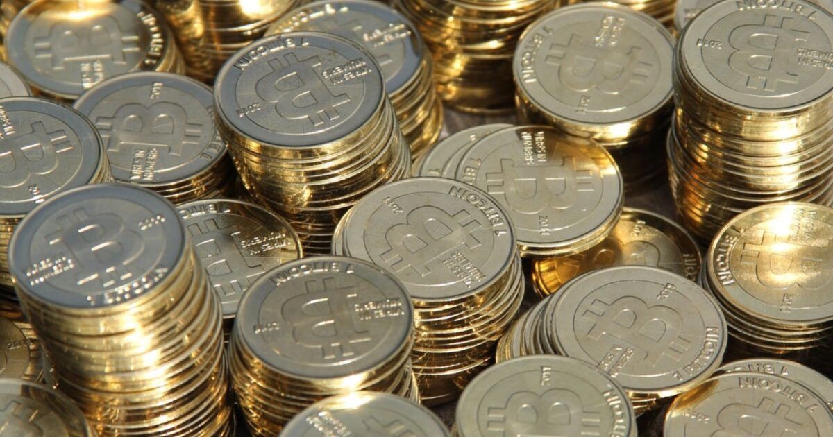 Stacks of physical Bitcoin coins representing a dormant 2011 wallet moving after nearly 15 years